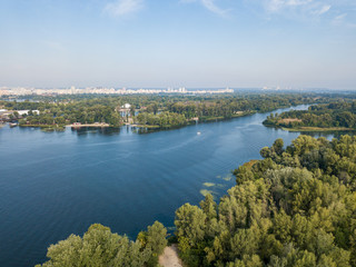 Obraz premium Aerial drone view. Green bank of the Dnieper river on a summer sunny day.