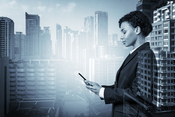 Attractive black African American business woman in suit using smart phone and thinking how to tackle the problem, new career opportunities, MBA. Bangkok on background. Double exposure.