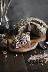 Zebra cake pieces on a wooden cutting board. Still life in dark shades. Homemade sweets.