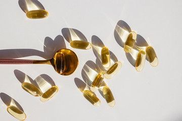 Omega 3 capsules on white table in natural sunlight