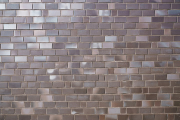 A fragment of a brick wall made of dark  brown bricks.