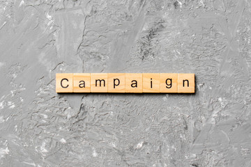 CAMPAIGN word written on wood block. CAMPAIGN text on cement table for your desing, concept