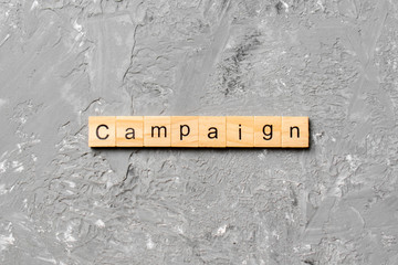 CAMPAIGN word written on wood block. CAMPAIGN text on cement table for your desing, concept