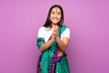 Young Indian woman with sari over isolated background applauding after presentation in a conference
