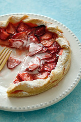 Galeta pie with fresh strawberries on blue background. Close up, selective focus