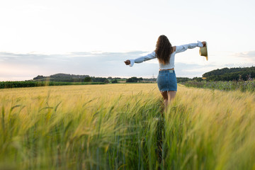 Glückliche junge Frau läuft durch ein Feld