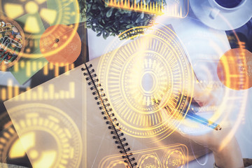 Tech theme hologram over woman's hands taking notes background. Concept of hightech. Double exposure