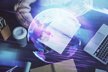 Tech theme hologram over woman's hands taking notes background. Concept of hightech. Double exposure