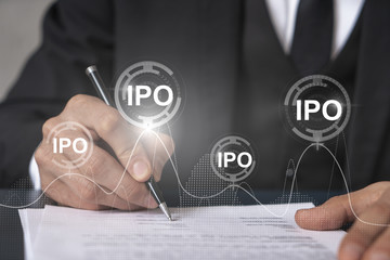 Businessman in suit signs paper. Double exposure with IPO icon hologram. Man signing contract...