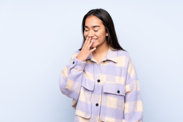 Young Indian woman isolated on blue background smiling a lot