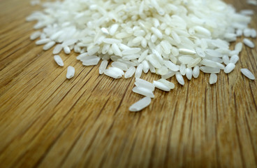 White rice isolated on wooden board with blur effect.