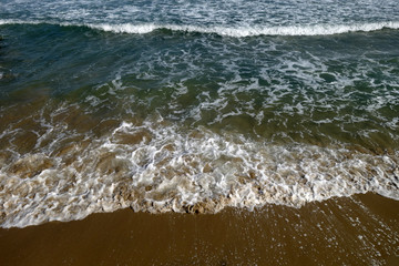 Sea wave and sandy beach.