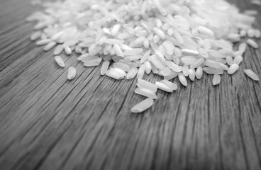 White rice isolated on wooden board with blur effect in black and white.