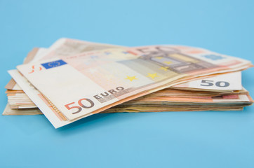 stack with 50 euros on a blue background.