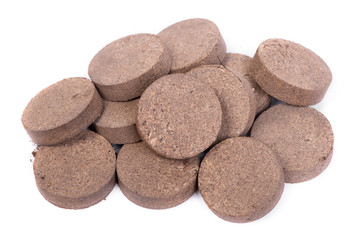 Dry peat pellets, compressed compost tablet isolated over the white
