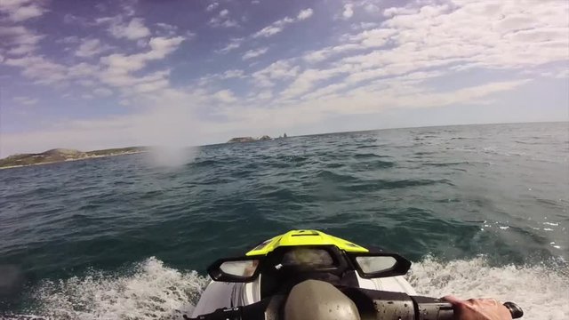Driving a jet ski on a rough wave water Sea on a Mediterranean Sea in Costa Brava, Catalonia from a driver point of view