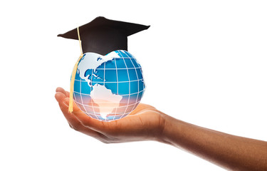 Hand holding globe in graduation cap over white