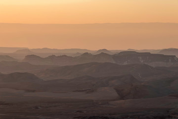 Ranges of Ramon Crater in the Negev Desert in the early morning in fog. Israel