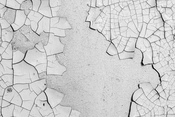 White peeling paint on the wall. Old concrete wall with cracked flaking paint. Weathered rough painted surface with patterns of cracks and peeling. High resolution texture for background and design.