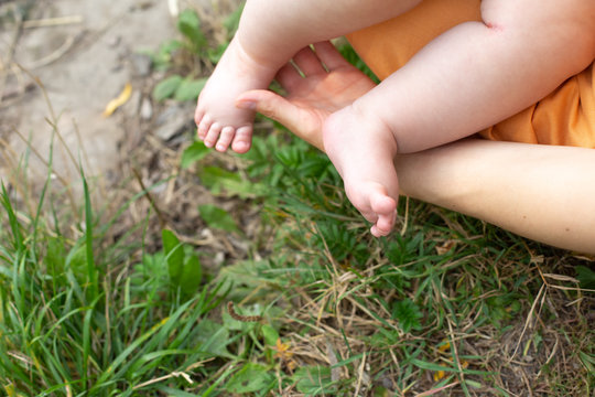 a small child in the arms of M. the feet of a small child