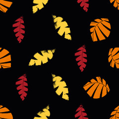 Mono print style scattered leaves seamless vector pattern background. Textured cut out yellow, red, orange on black backdrop. Hand crafted painterly stamp design. All over print for fall products