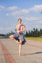 Young and beautiful ballerina posing on the street