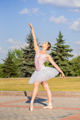 Obraz premium Young and beautiful ballerina posing on the street