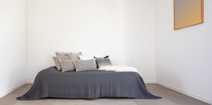 Nice bedroom with a bed and lots of pillows. Detail of the bed with a large white wall, perfect for copy space