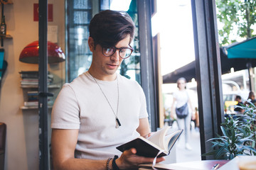Concentred young man searching information in notebook