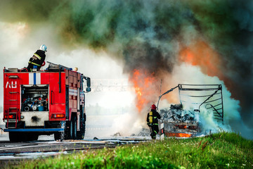 firefighter extinguishes a burning car after an accident