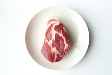 豚肩ロースのブロックと白い皿