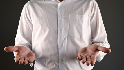 a man in a white shirt makes a helpless gesture