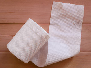 Simple toilet paper on wood background.