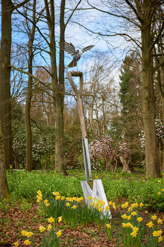 An oversized spade with a metal Bird alighting on it, one of the many Horticultural sculptures at Harlow Carr Garden centre in Yorkshire.