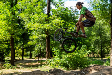 Fototapeta na wymiar A bmx cyclist doing a trick in flight. Jump on a bike from a springboard.
