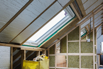 Loft conversion, unfinished project, silver insulation, roof windows, wood structure of the walls, selective focus
