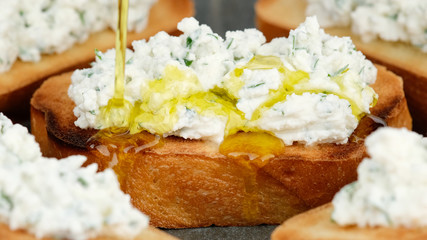 pour olive oil on bruschetta with ricotta cheese and herbs. Healthy appetizer © Евгений Логвиненко