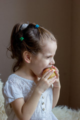 Funny little girl kid eats an apple