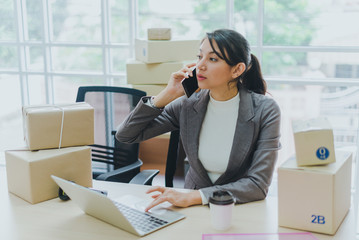 A beautiful businesswoman working at home is checking orders for products to be delivered to her...