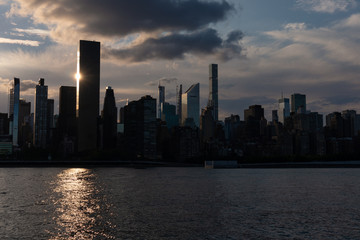 Fototapeta premium Beautiful Silhouettes of Skyscrapers in the Midtown Manhattan Skyline during a Sunset along the East River in New York City