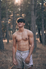 Foto en medio de un bosque con un joven musculoso 