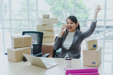 A beautiful businesswoman working at home is checking orders for products to be delivered to her...
