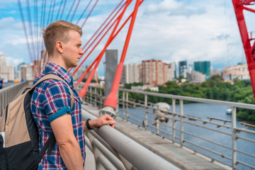 A young man stands on the picturesque red bridge in Moscow, bottom photo, face close-up