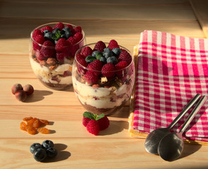 Triffle dessert in a glass. Berry nut ingredients, for the preparation of a vitamin dessert. Honey biscuit with raisins and nuts, stands on the table.