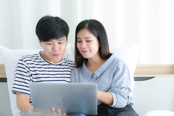 Asian couple of lesbian woman using laptop together on bed,lgbt lifestyle concept.