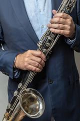 Obraz premium Close-up of male hands holding bass clarinet, cropped photo