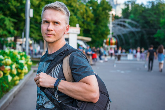  Portrait of a young man with backpack in Sokolniki Park in Moscow under an arch with lanterns
