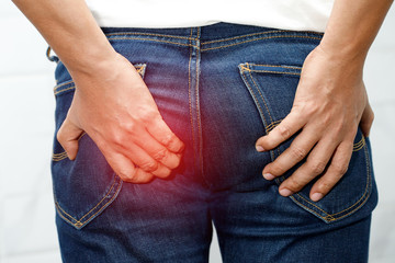 Man with hemorrhoids holding his butt in pain because having abdominal constipation and itching in the anus or anorectal abscess, Health care concept. 