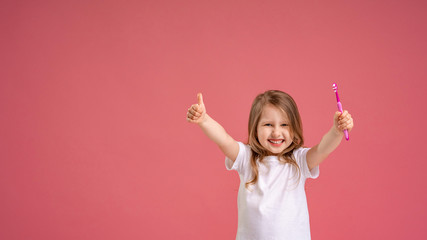 cheerful little girl smiles with healthy white teeth, and shows class