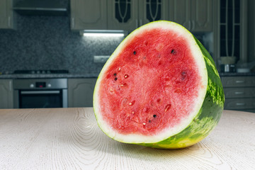 Half a ripe watermelon lying on the kitchen table